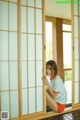 A woman sitting on the floor in front of a sliding door.