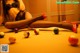 A woman sitting on top of a pool table surrounded by balls.