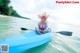 A woman in a blue kayak paddling on the water.