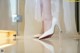 A close up of a woman's shoes on a table.