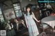 A woman standing in a living room next to a table.