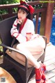 A woman in a red and white outfit sitting on a chair.